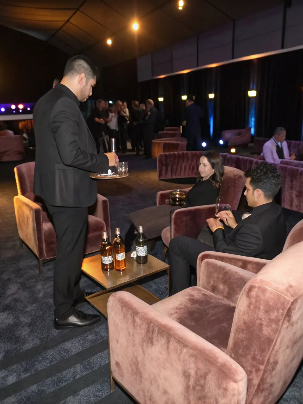 A VIP lounge at a major event in Abu Dhabi, such as the Formula 1 Grand Prix, with guests enjoying premium drinks and canapés. The image should convey exclusivity and excitement.